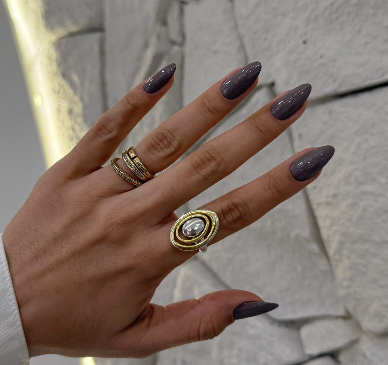 ong almond shaped nails with a solid, high-gloss slate grey gel polish.