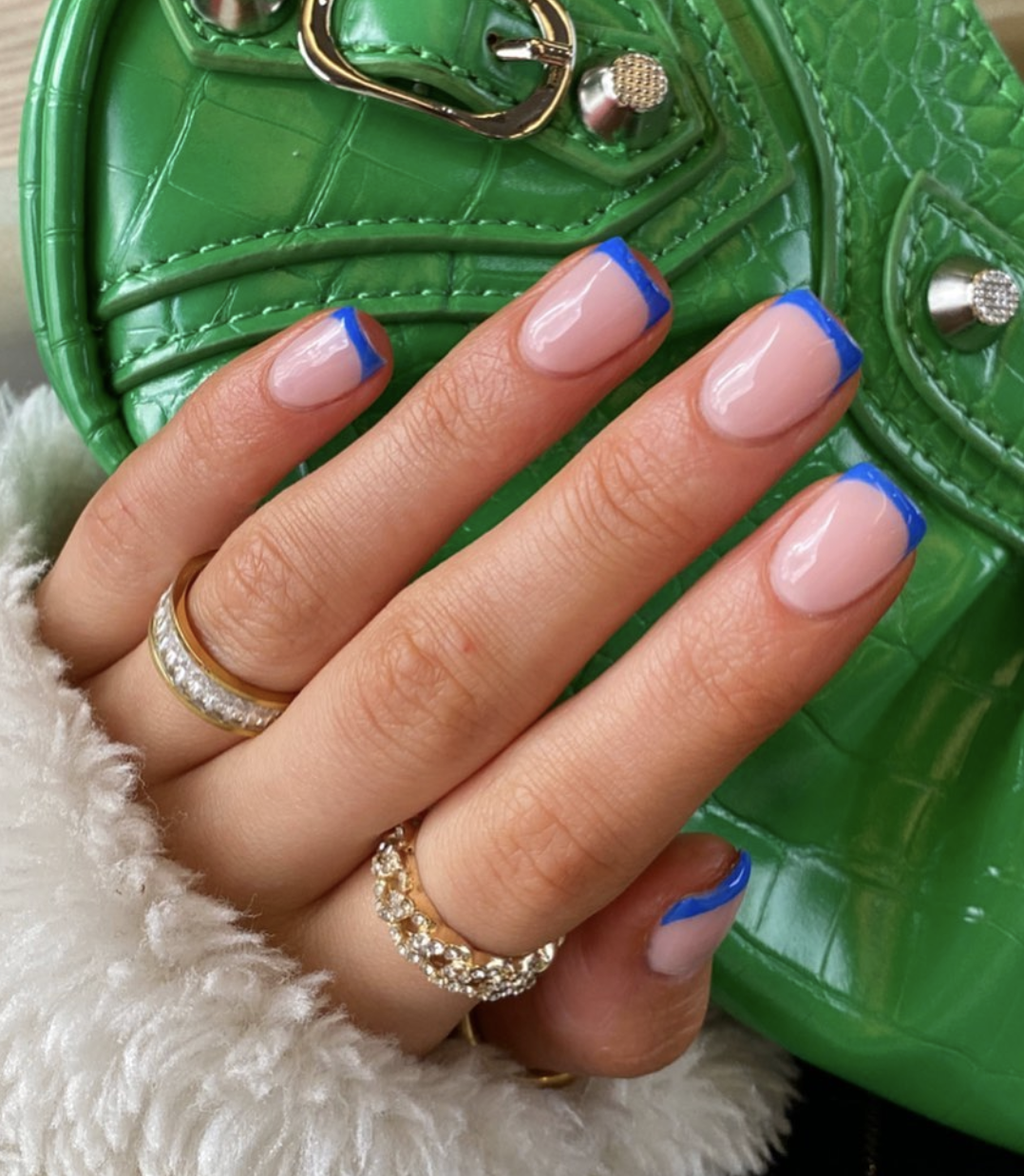 Short nails with thin cobalt blue French tips and a sheer pink base