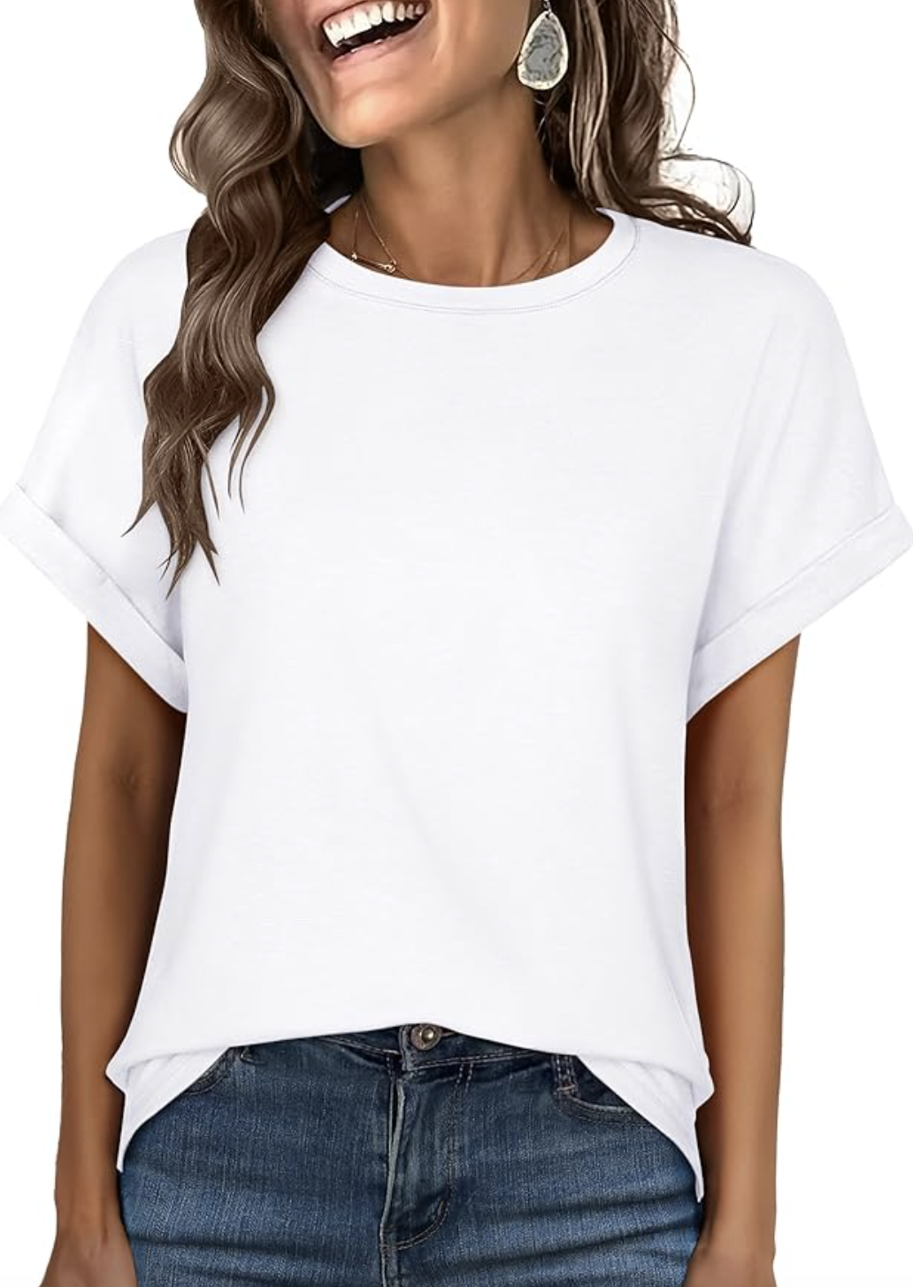 A woman wearing a crisp white oversized short-sleeve t-shirt with a structured crew neck, styled half-tucked into jeans as an essential spring wardrobe piece for women in their 50s.