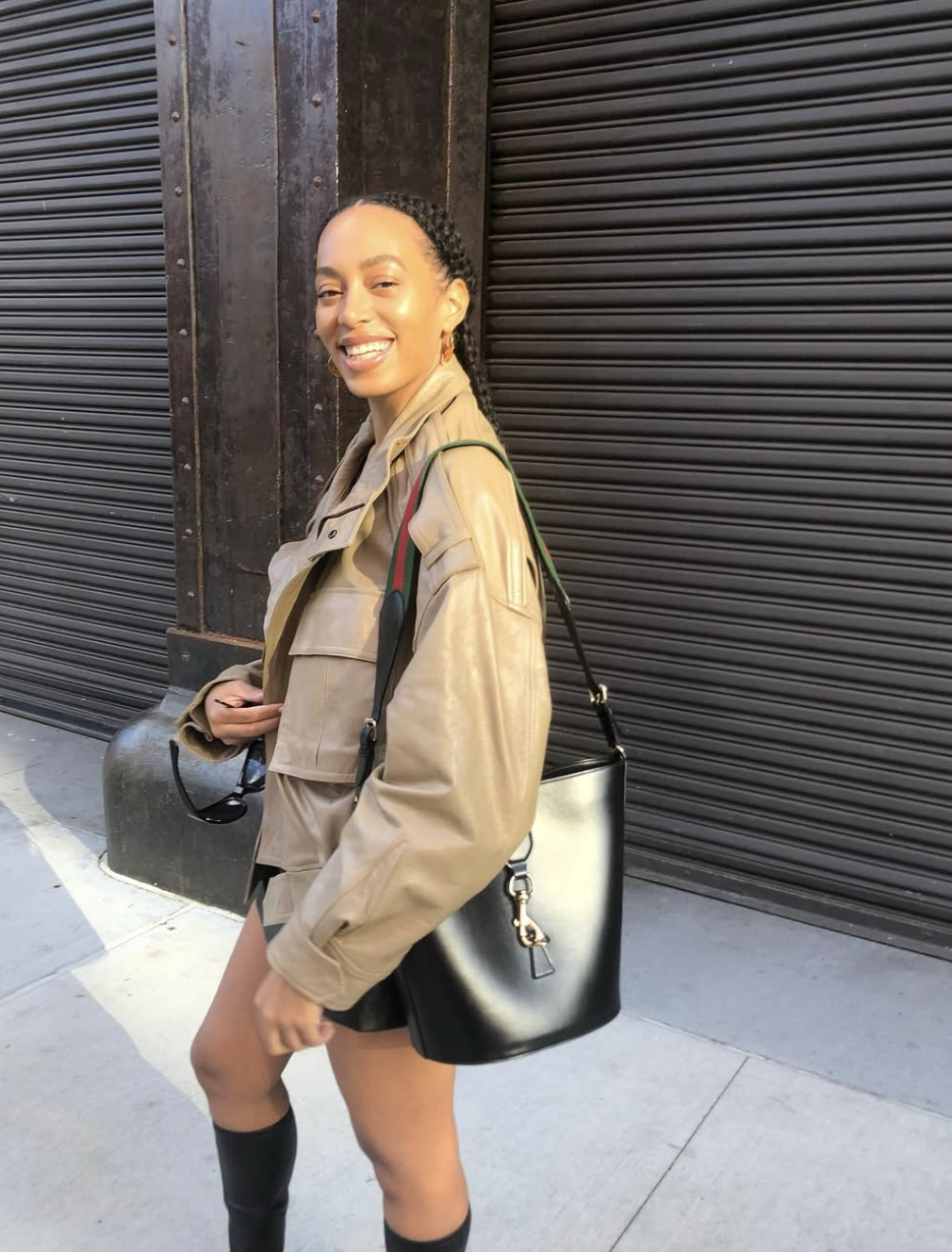 Solange Knowles wearing a muted olive-tan trench coat, illustrating how warm-neutral undertones and soft, blended coloring align with the Soft Autumn season.