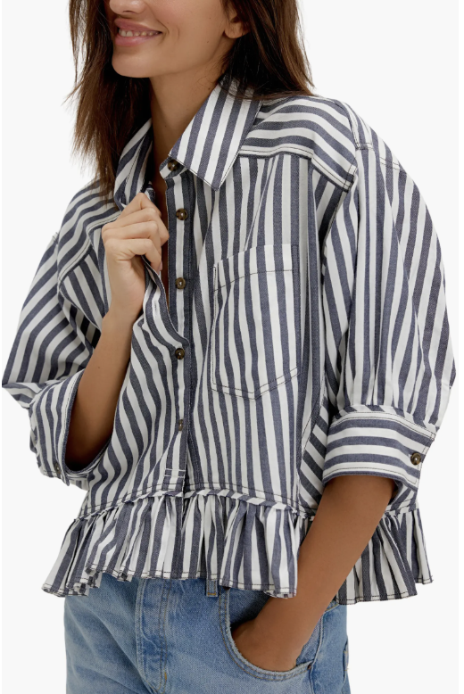 Product shot of the Free People Bailey Stripe ruffle hem cotton button-up shirt in blue and white stripes, featured as a loose, drapey top to pair with baggy jeans.