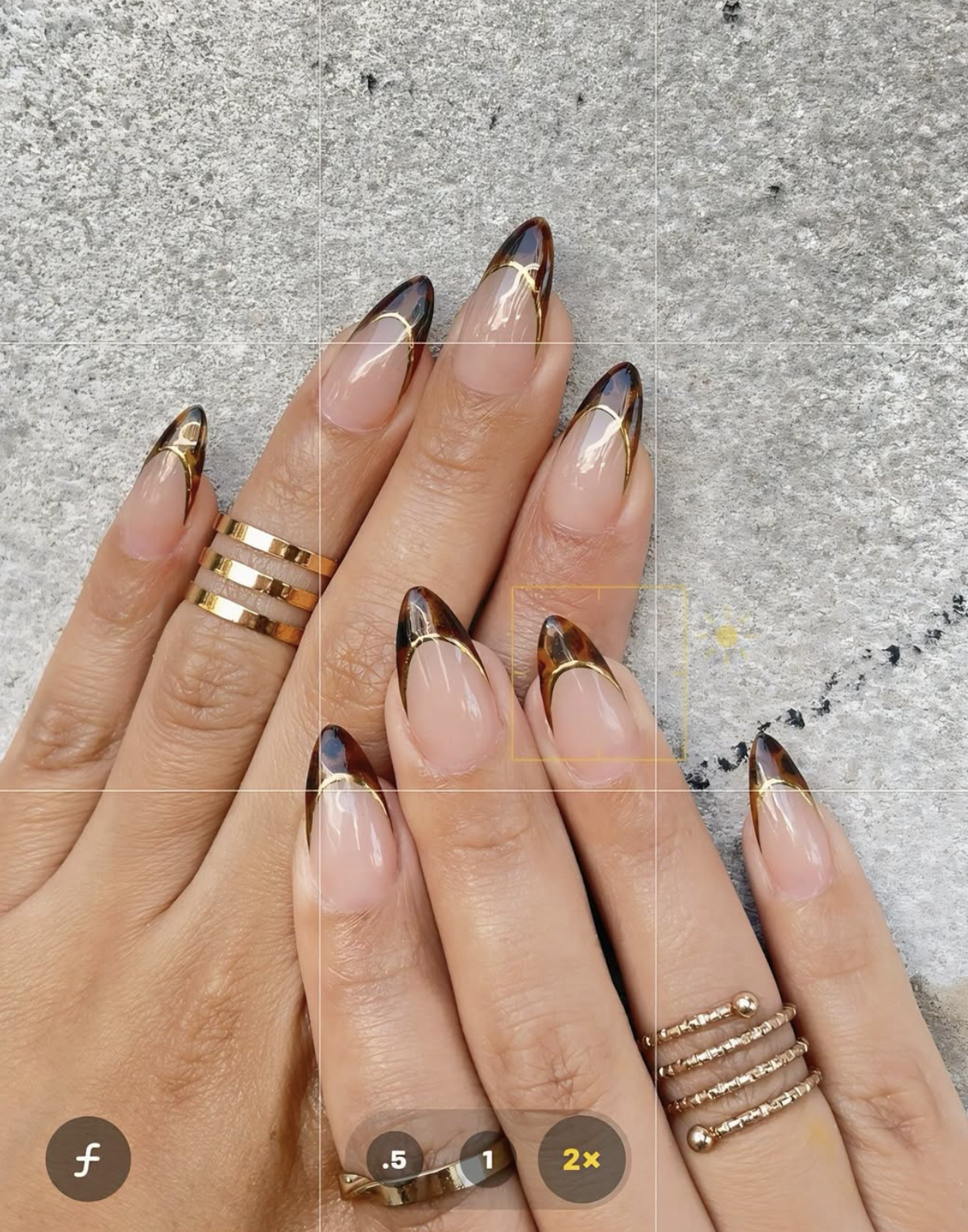 caramel nude nails with gold micro-details manicure photographed close up on hands.