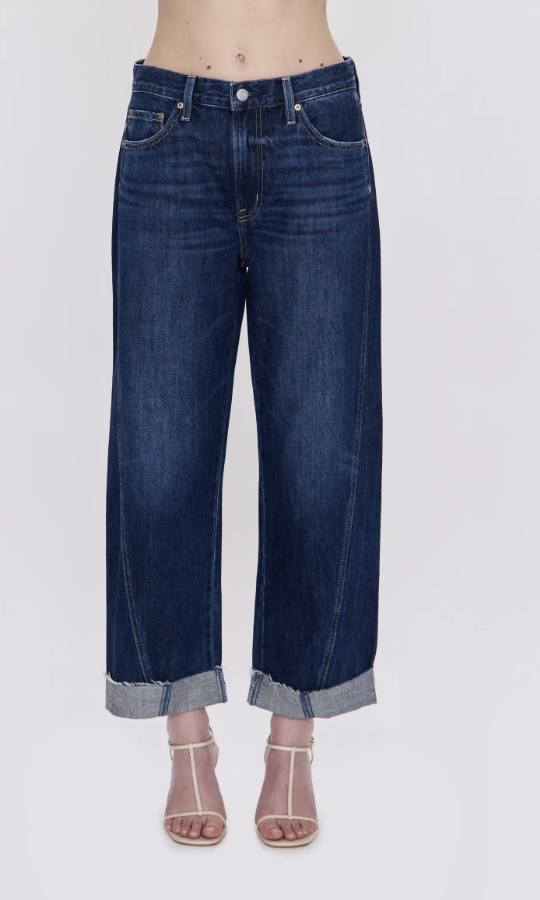 Dark cuffed wide-leg jeans paired with pink strappy heels.