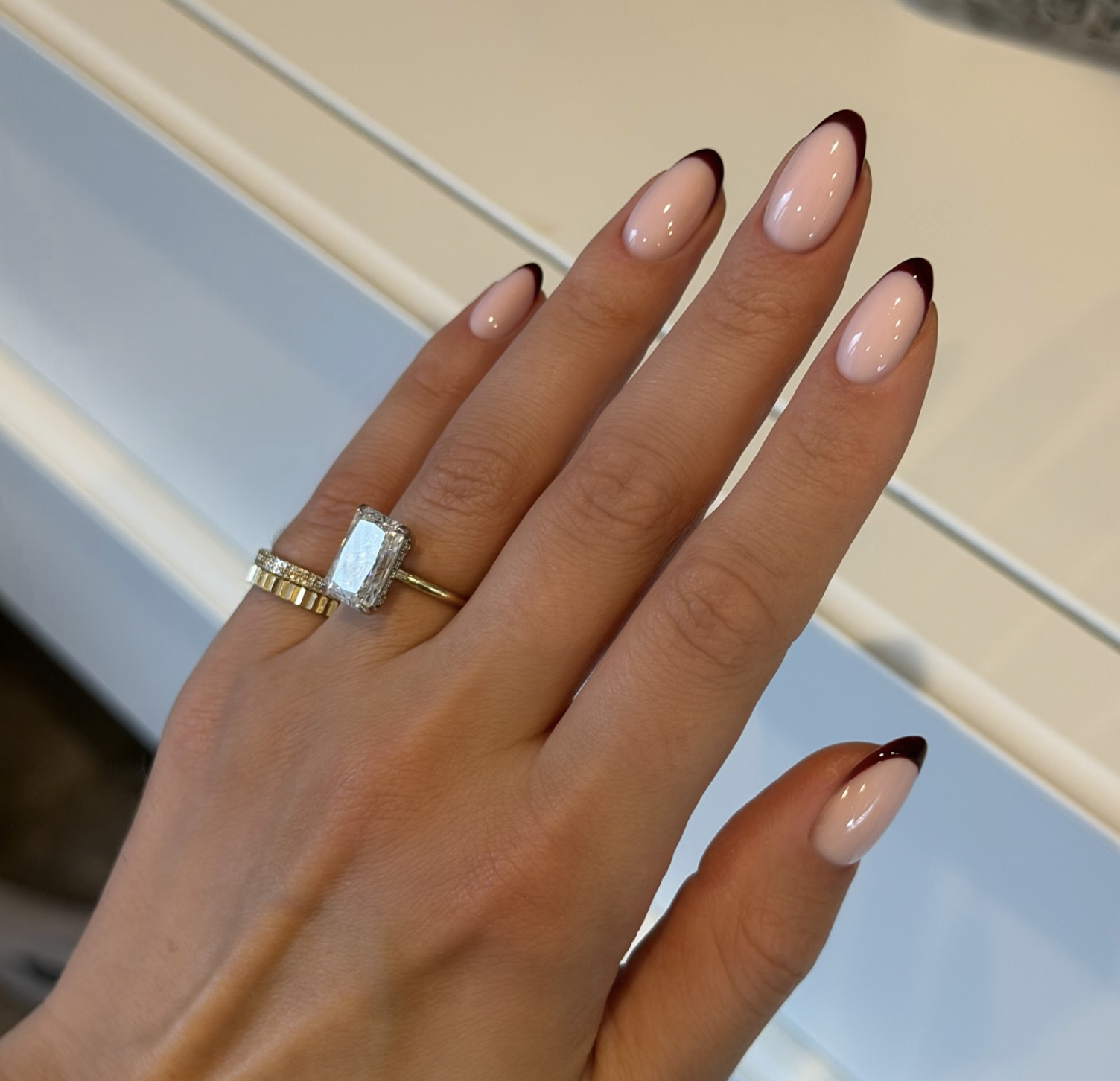 Short nails with a sheer pink base and delicate burgundy micro French tips