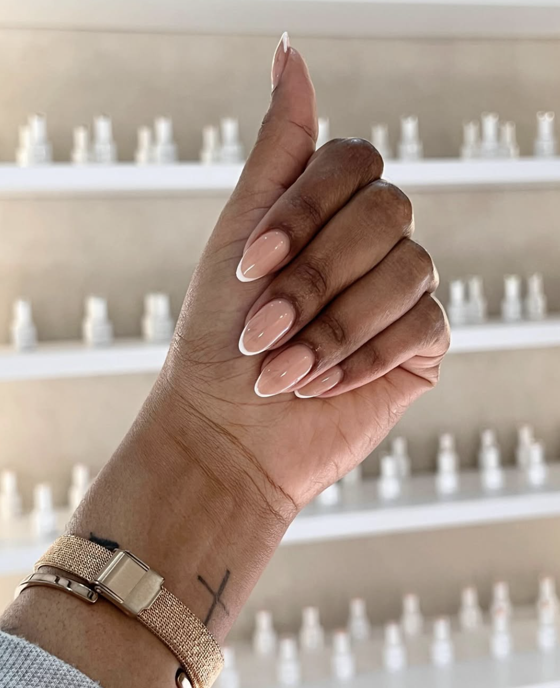Long almond shaped nails with a natural nude base and a very thin white micro-french tip.