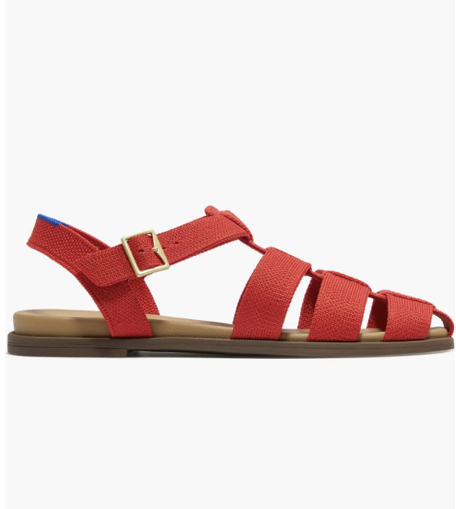 Close-up of The Fisherman Sandal by Rothy's in vibrant red knit fabric featuring a woven strap design, matching ankle strap with a gold buckle, and a flat tan sole.