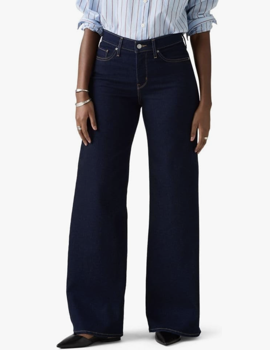 A studio product shot showing the lower half of a person wearing dark wash Levi's 318 Shaping Wide Leg jeans paired with pointed-toe black flats.