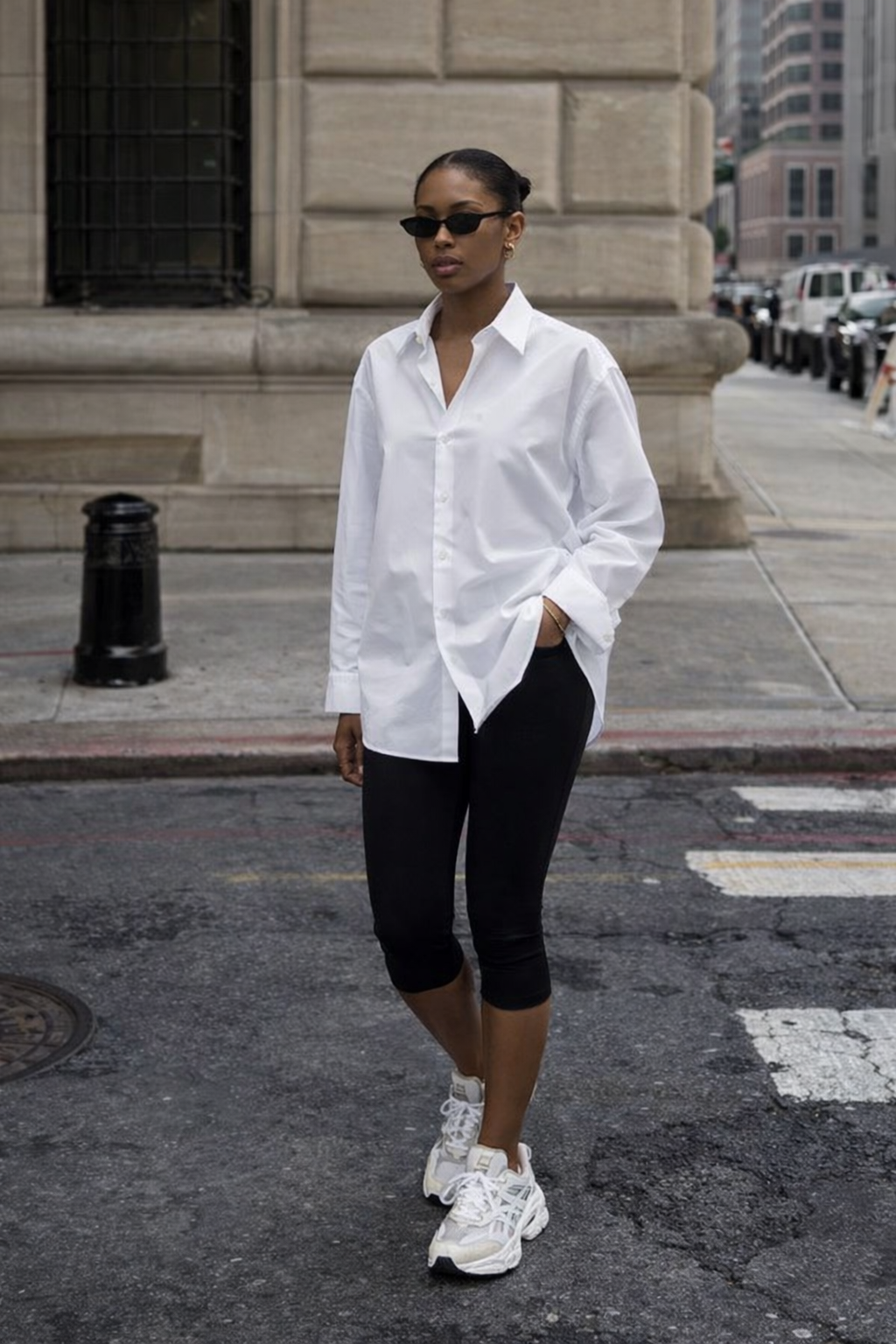 A pair of black strappy high-heel sandals with a delicate wrap-around ankle strap and a gold stiletto heel.