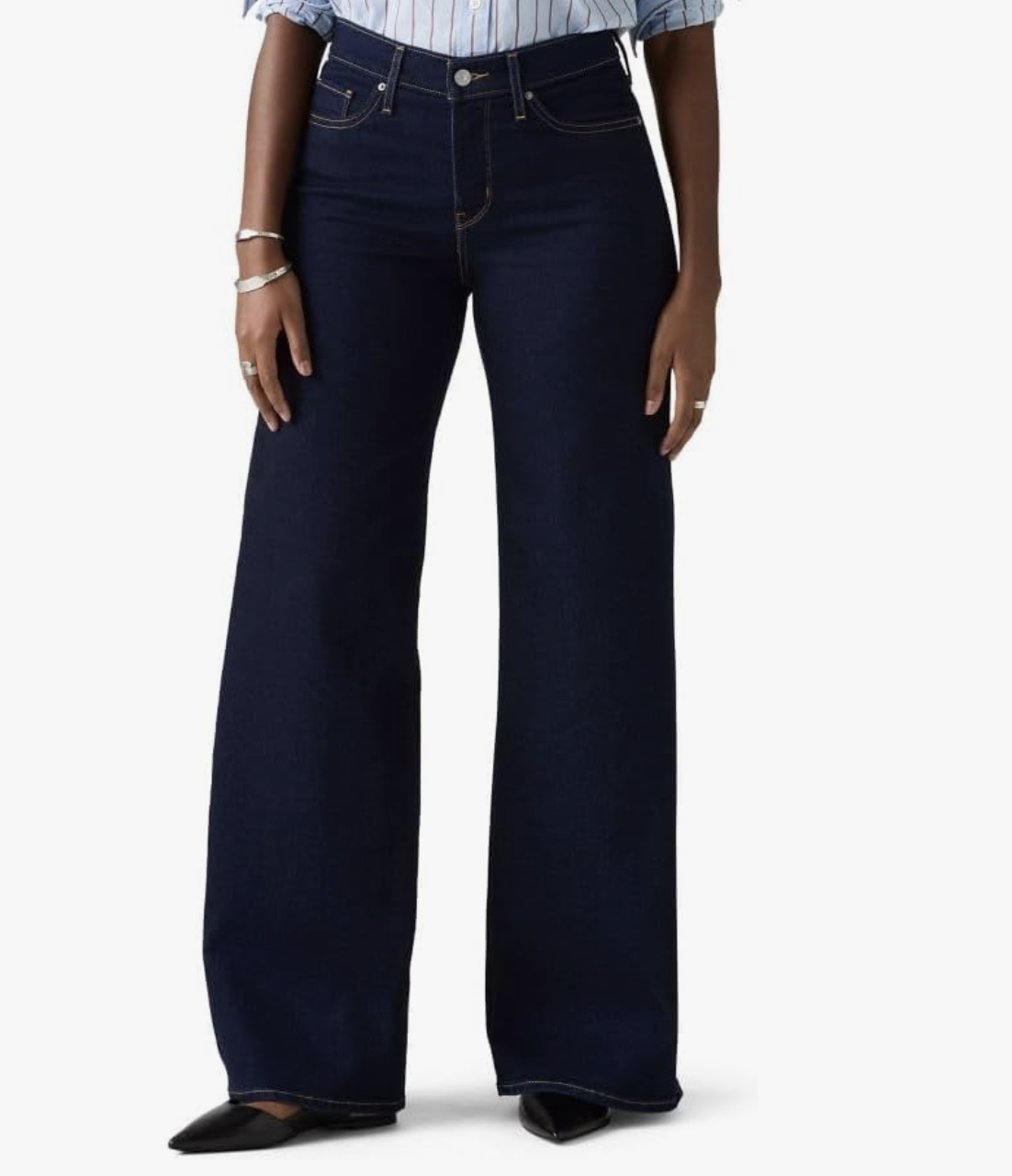 A person wearing dark-wash Levi's 318 Shaping Wide Leg jeans paired with black pointed-toe flats, shown from the waist down on a white background.