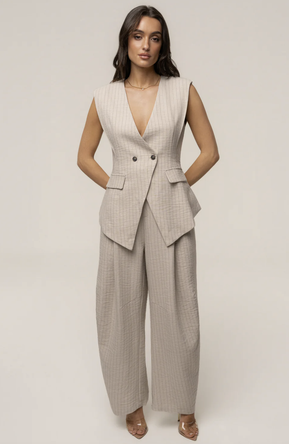 A chic beige and white pinstriped two-piece matching set featuring a relaxed-fit button-down top and fluid wide-leg trousers.