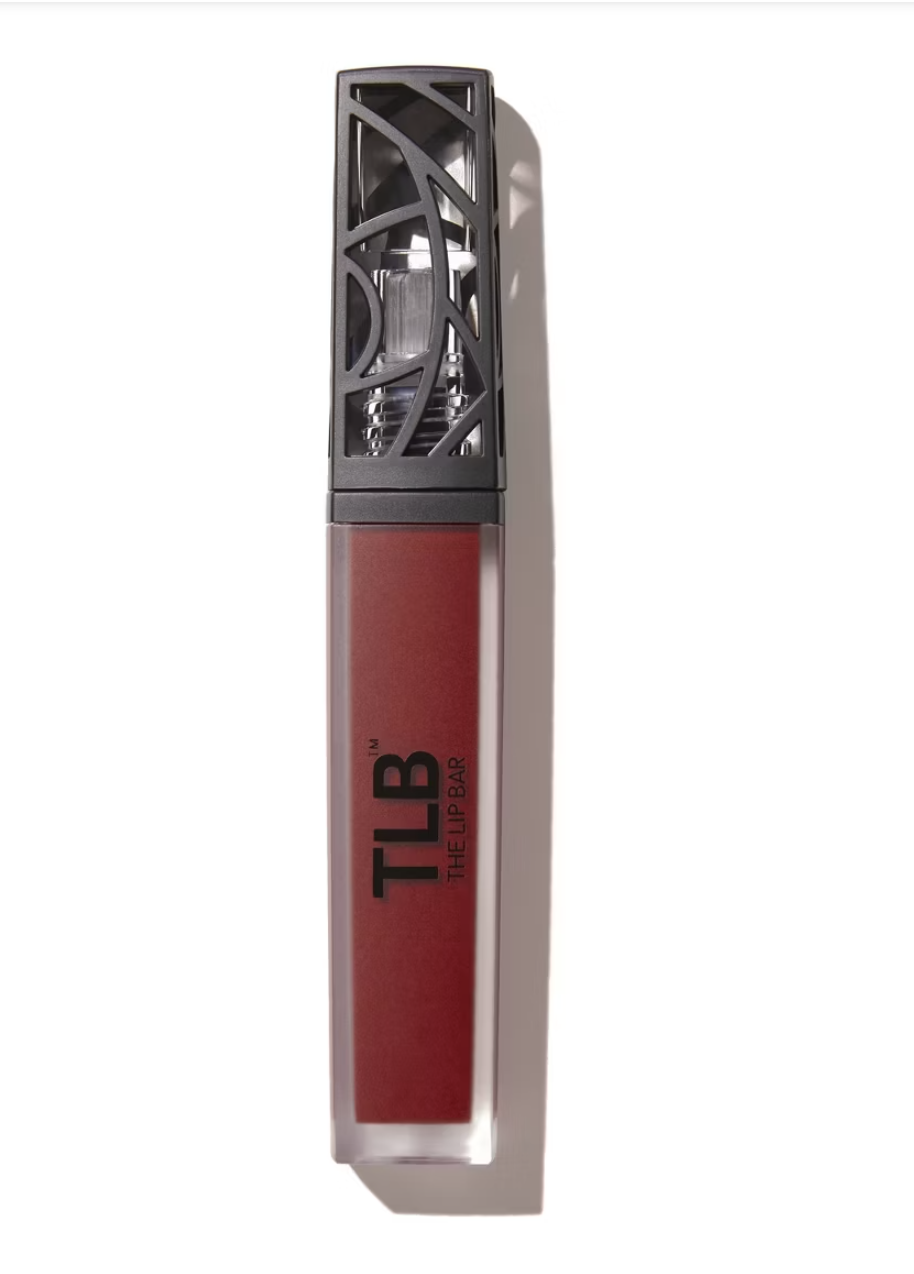 The Lip Bar Bawse Lady Liquid Matte Lipstick in a sleek, architectural clear tube with a black patterned cap, featuring a bold, universal red pigment for all skin tones.