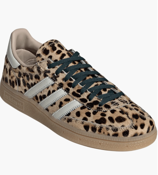 A product shot of the Adidas Handball Spezial sneakers in a leopard print pony hair texture with black laces. These shoes are recommended as the "undone" finishing touch for styling a modern power suit set.