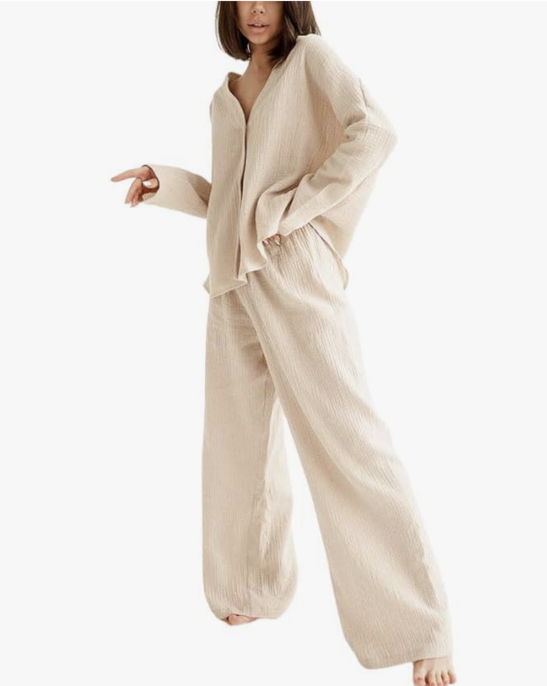 A woman wearing a relaxed, oversized two-piece linen matching set in an ecru cream color, featuring a button-down long-sleeve shirt and wide-leg trousers.