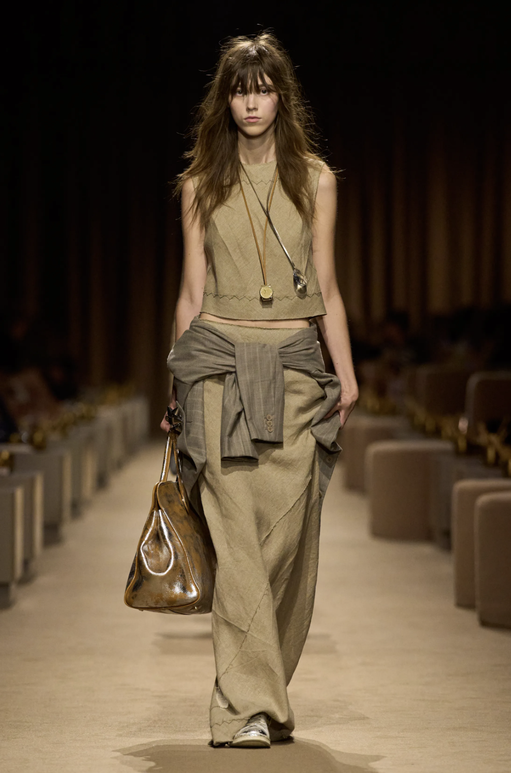 Coach Spring 2027 runway layered look with a long, light trench coat