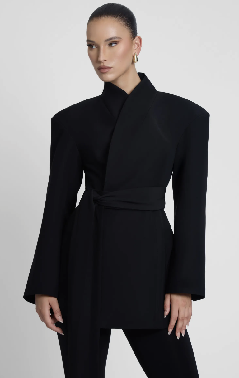 A studio product shot of the L'EAU Cairo Hourglass Belted Coat in black, featuring a structured high-neck collar, cinched hourglass waist, and belted detail.