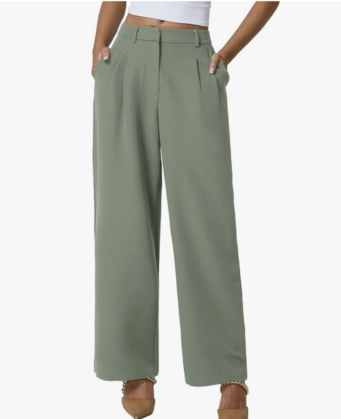 A woman styling sage green wide-leg pull-on trousers with a high-waisted fit and pleated front, paired with a white top for a comfortable spring outfit for women in their 60s.