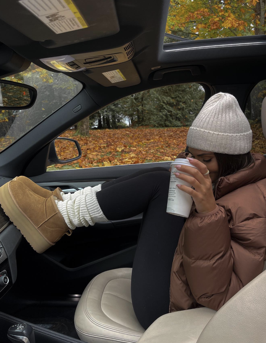 Chocolate puffer jacket and black leggings with cream socks, a cream beanie and chestnut platform boots.