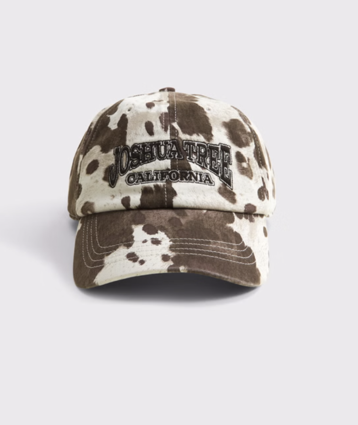A brown and white embroidered Joshua Tree baseball hat, used as a casual accessory for a sporty-chic blazer outfit.