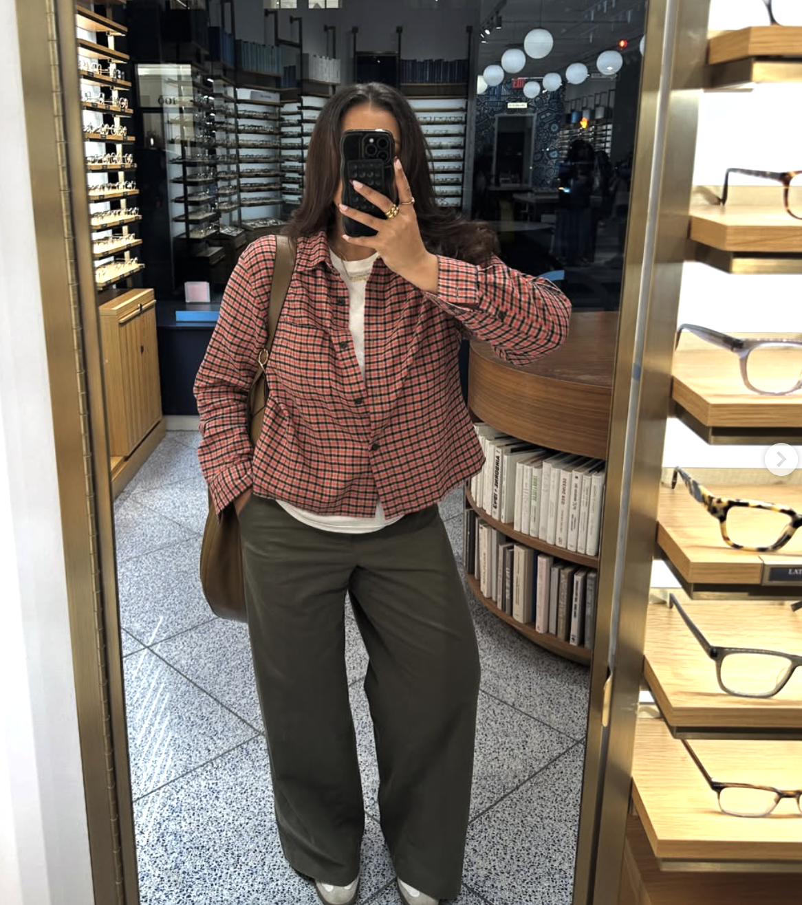 pro stylist-inspired layering formula featuring an unbuttoned red plaid shirt worn over a white t-shirt with olive green wide-leg trousers.