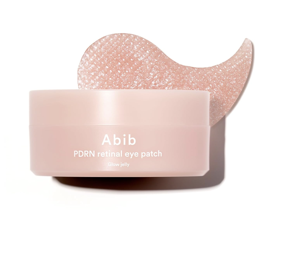 A jar of Abib PDRN Retinal Eye Patches in 'Glow Jelly' texture, featuring a light pink container and a shimmering pink hydrogel eye patch resting on top."