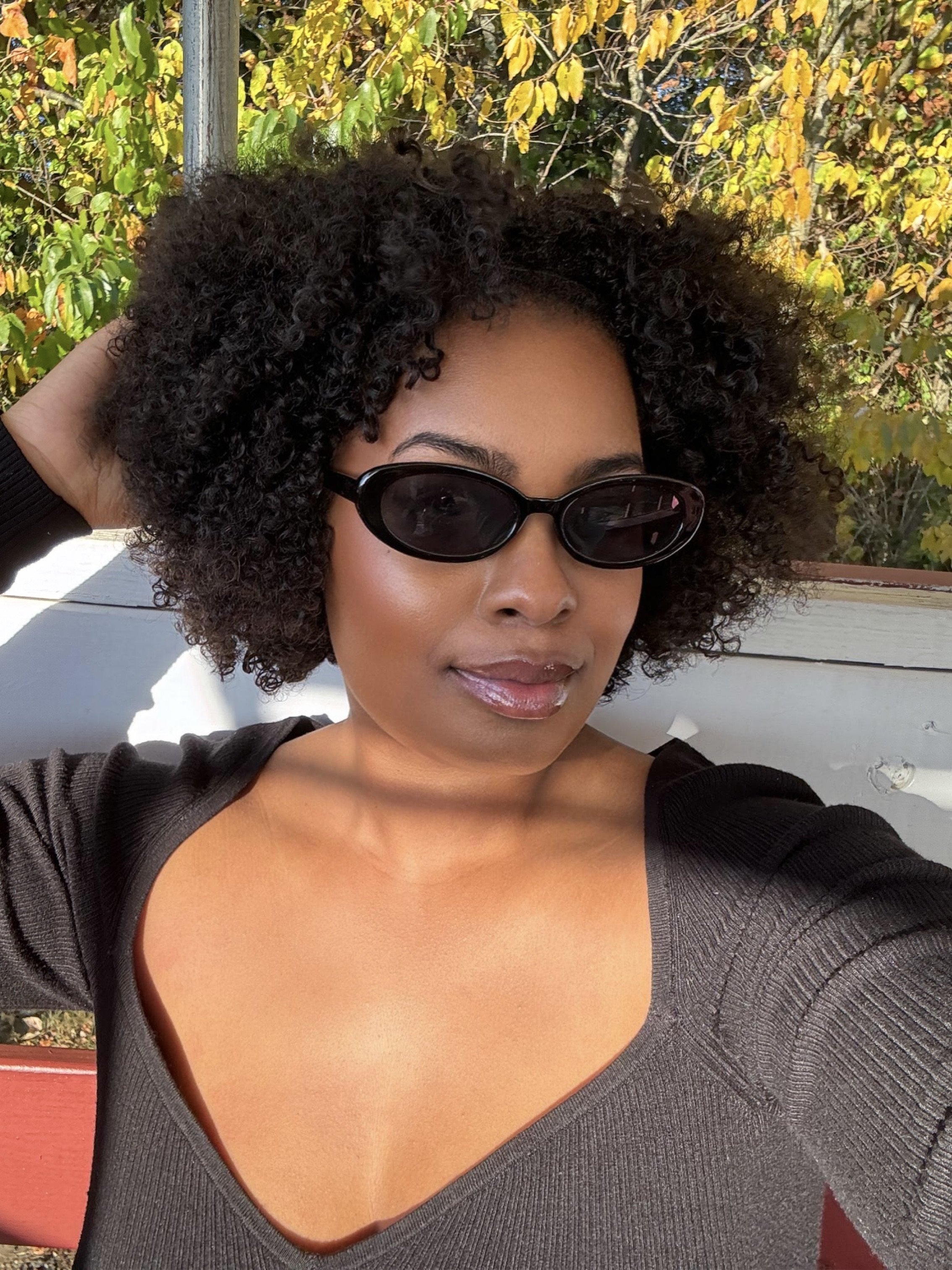 A woman with healthy, hydrated natural hair coils representing the moisture protein balance.