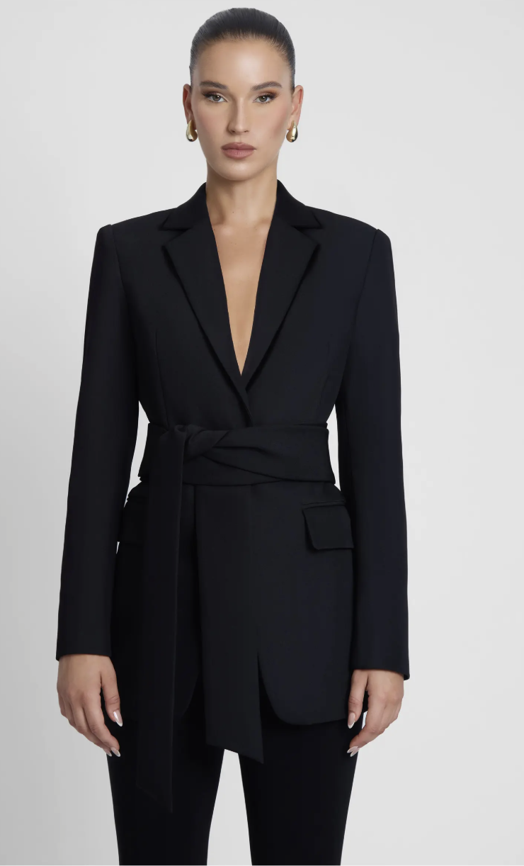 A woman wearing the black LEAU Classic Column Tailored Belted Blazer with a cinched waist and structured shoulders, epitomizing the quiet money aesthetic.