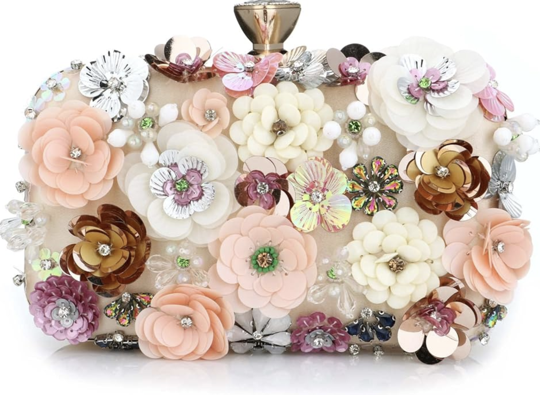 An elegant ivory evening clutch covered in 3D fabric flowers in shades of peach, pink, and white, accented with iridescent sequins and gold-centered floral charms.