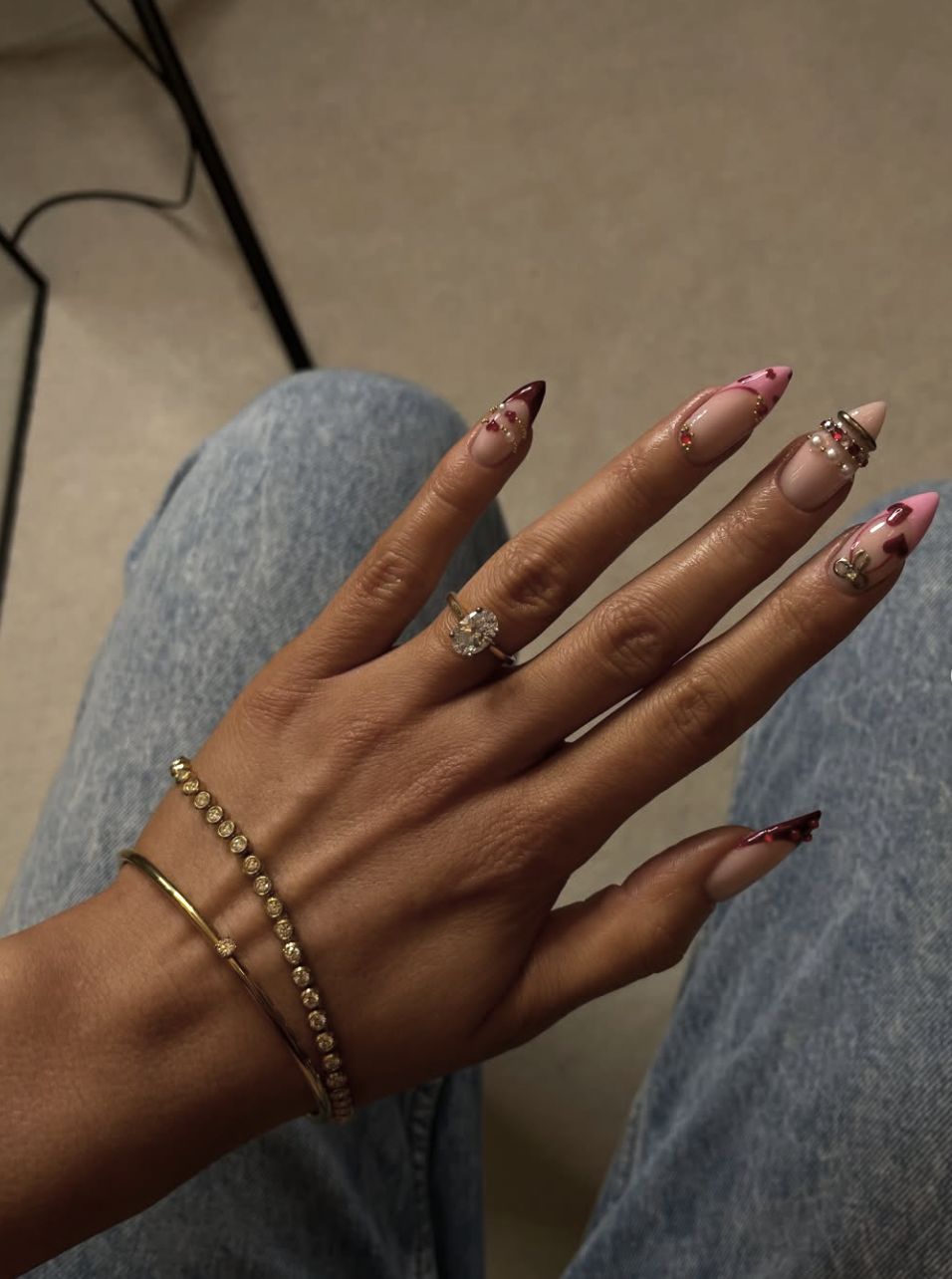 Long almond nails with light and dark pink 3D sculpted bangle designs and tiny floral accents.