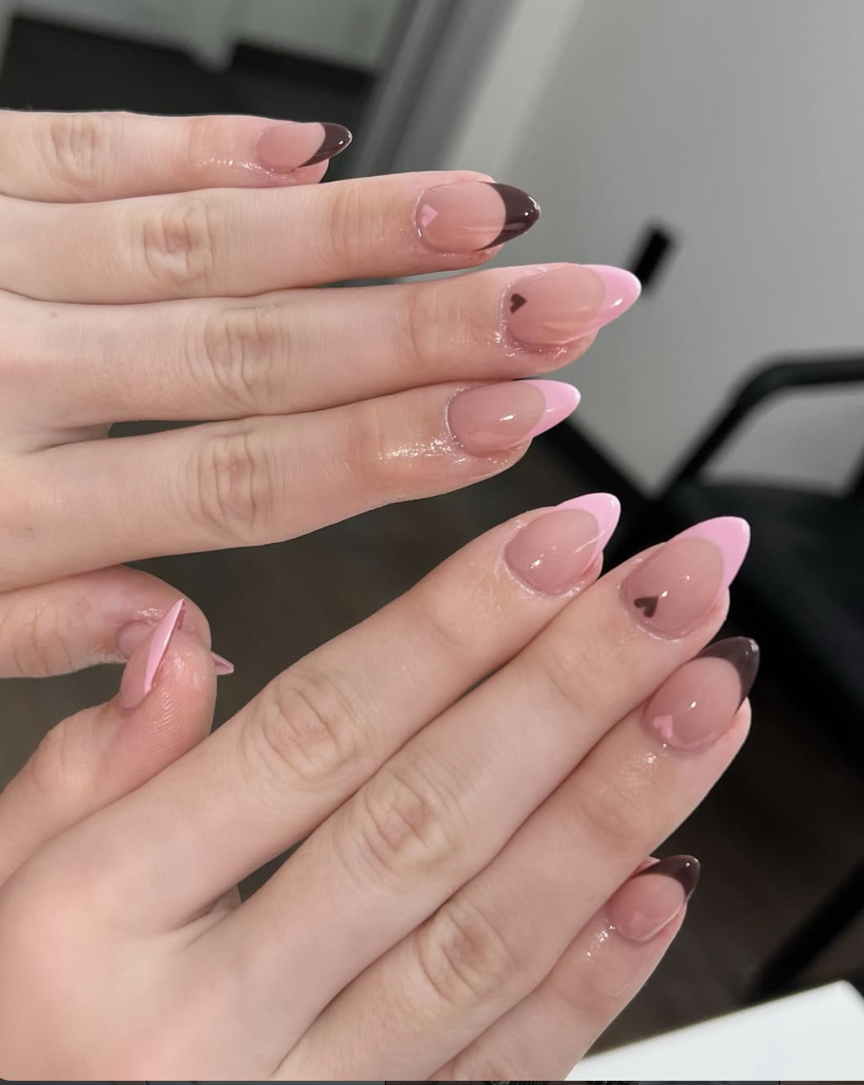Sheer pink nails with thin chocolate-brown French tips.