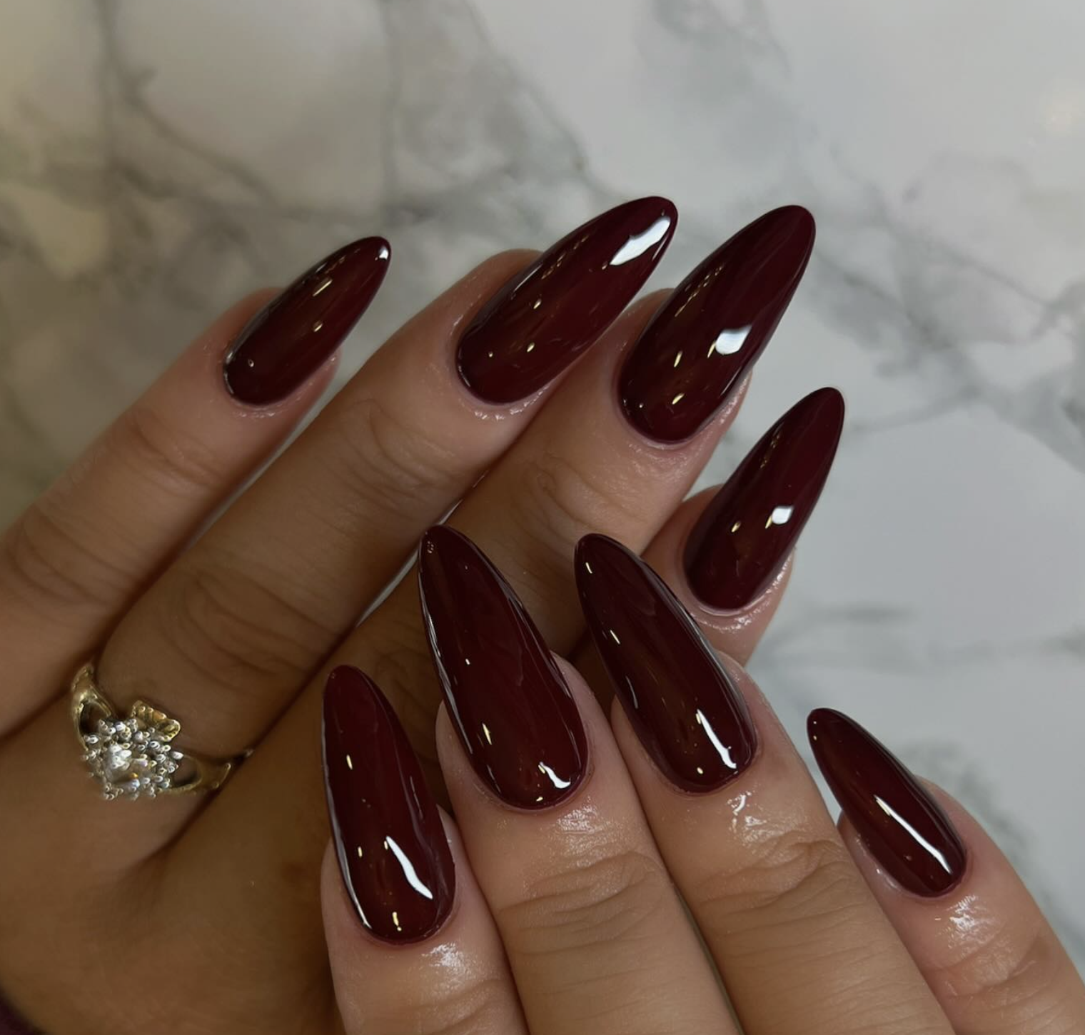 Deep burgundy polish on medium almond-shaped nails