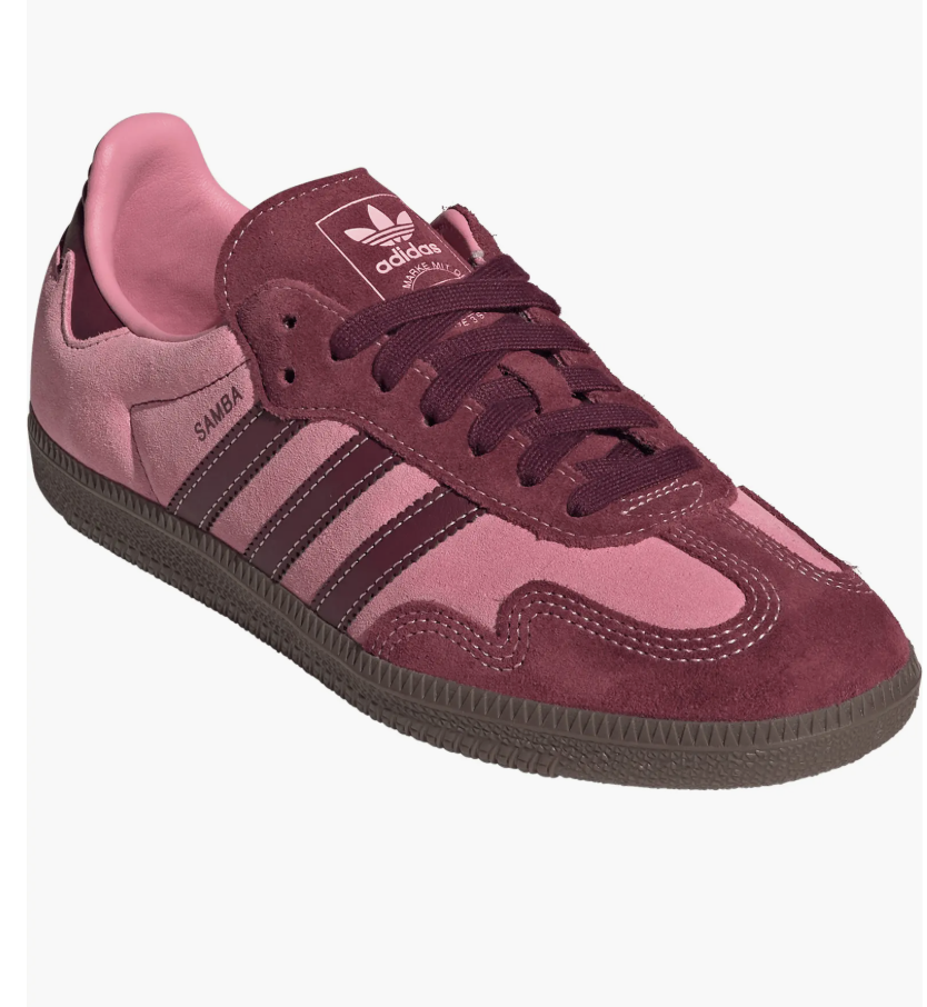 A pair of pink and burgundy Adidas Samba sneakers with classic white stripes and a gum sole, shown on a transparent background.