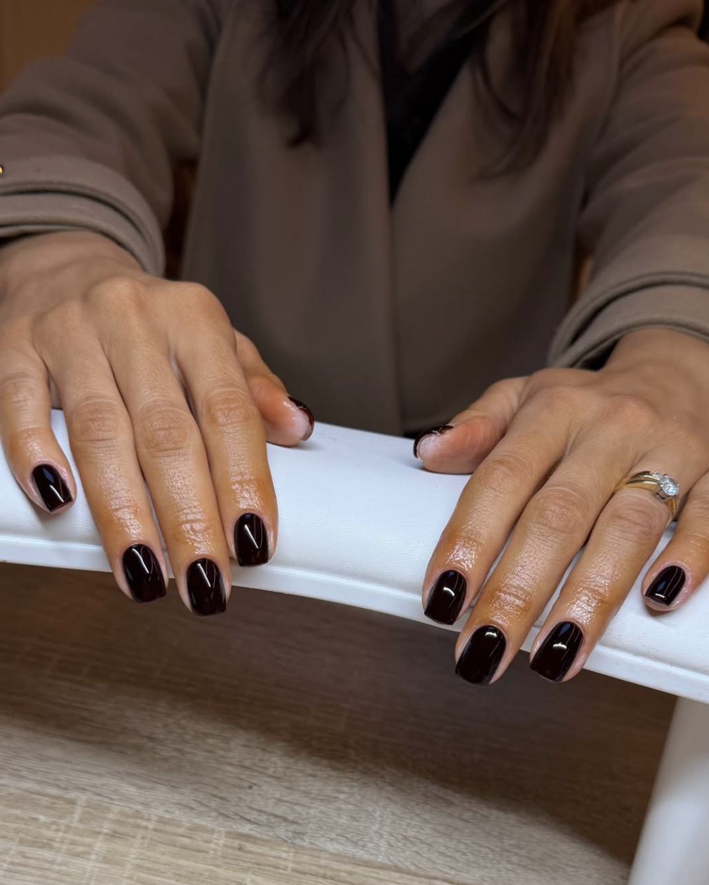 Short rounded nails painted high-gloss espresso brown for fall 2026.