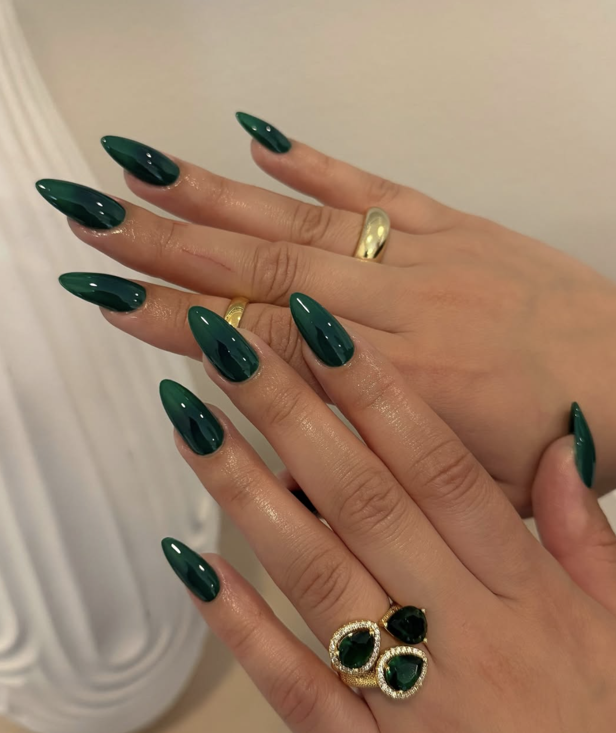 Glossy deep forest green polish on neatly shaped nails.