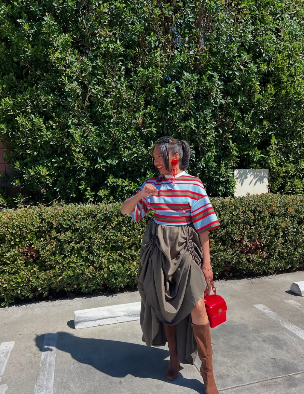 woman wearing a striped top and wrap skirt posing