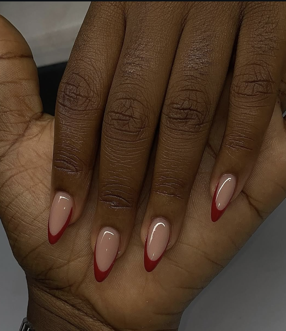 Short winter nails with red French tips and a sheer pink base