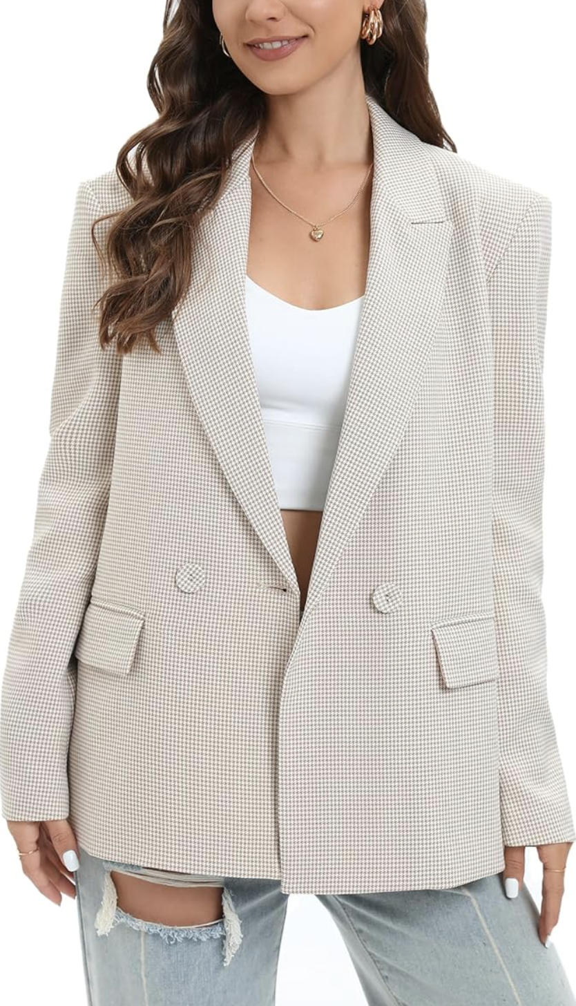 A woman wearing a beige double-breasted textured blazer over a white top and distressed light-wash jeans.