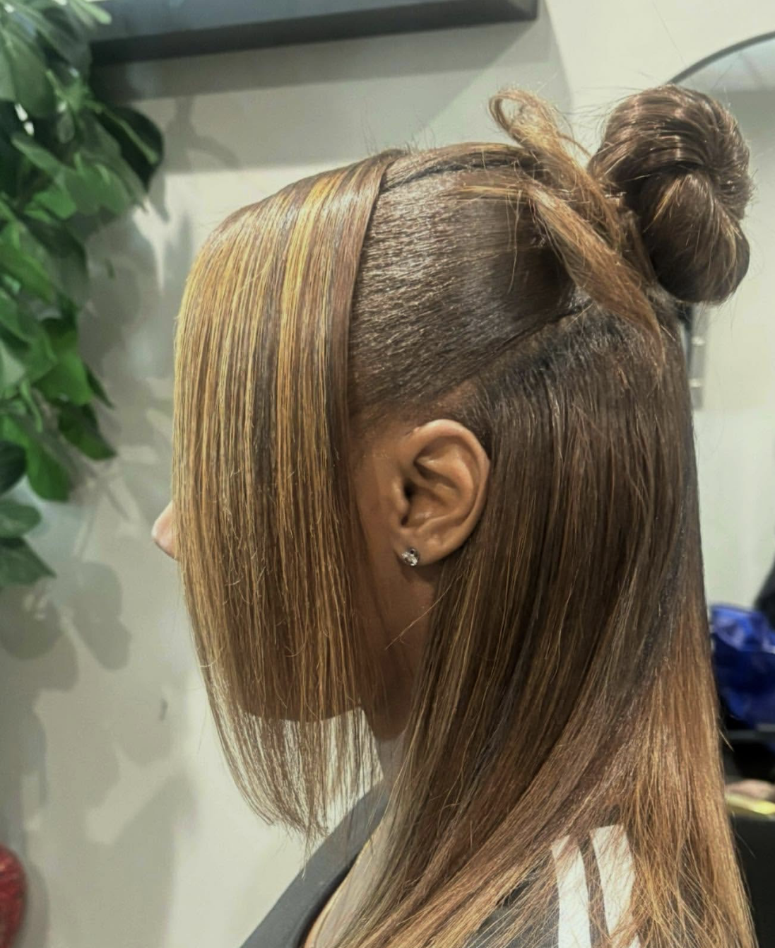 Half-up silk press hairstyle with caramel balayage and a face-framing bang"