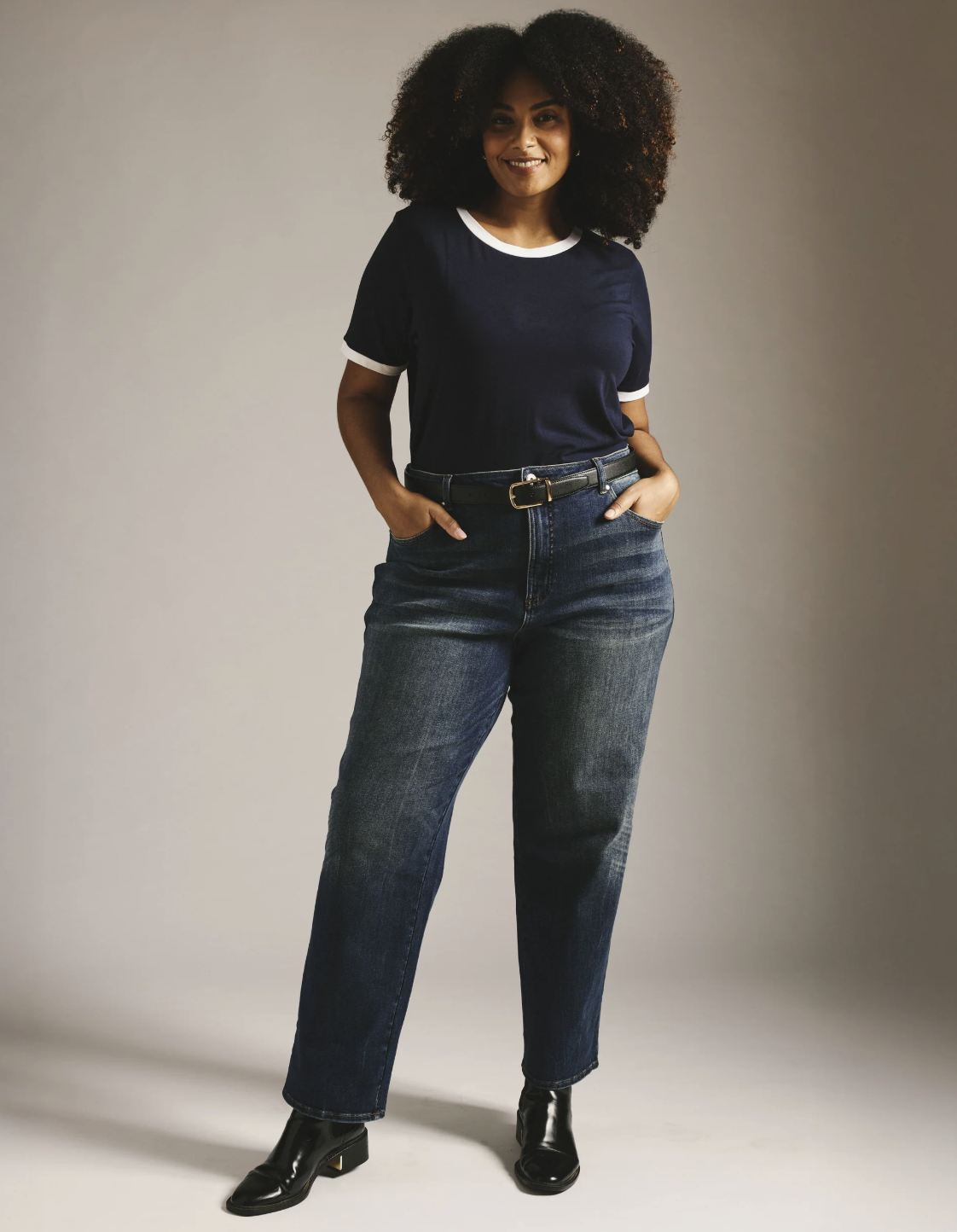 Woman wearing Universal Standard Donna high-rise straight-leg jeans with a smooth, contoured waistband.