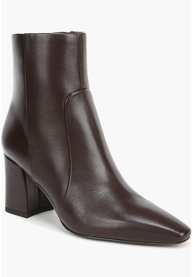 A close-up shot of a dark chocolate brown leather ankle boot featuring a structured block heel and a pointed toe, a versatile staple for a fall capsule wardrobe.