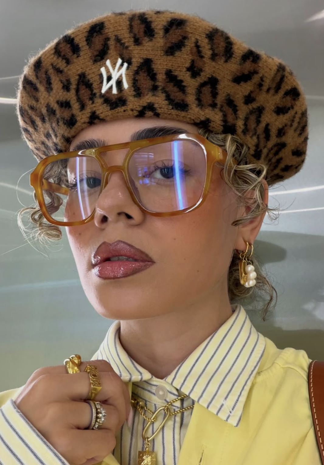 Woman wearing glasses in a stylish outfit, cover image for a guide to choosing eyeglasses by face shape.