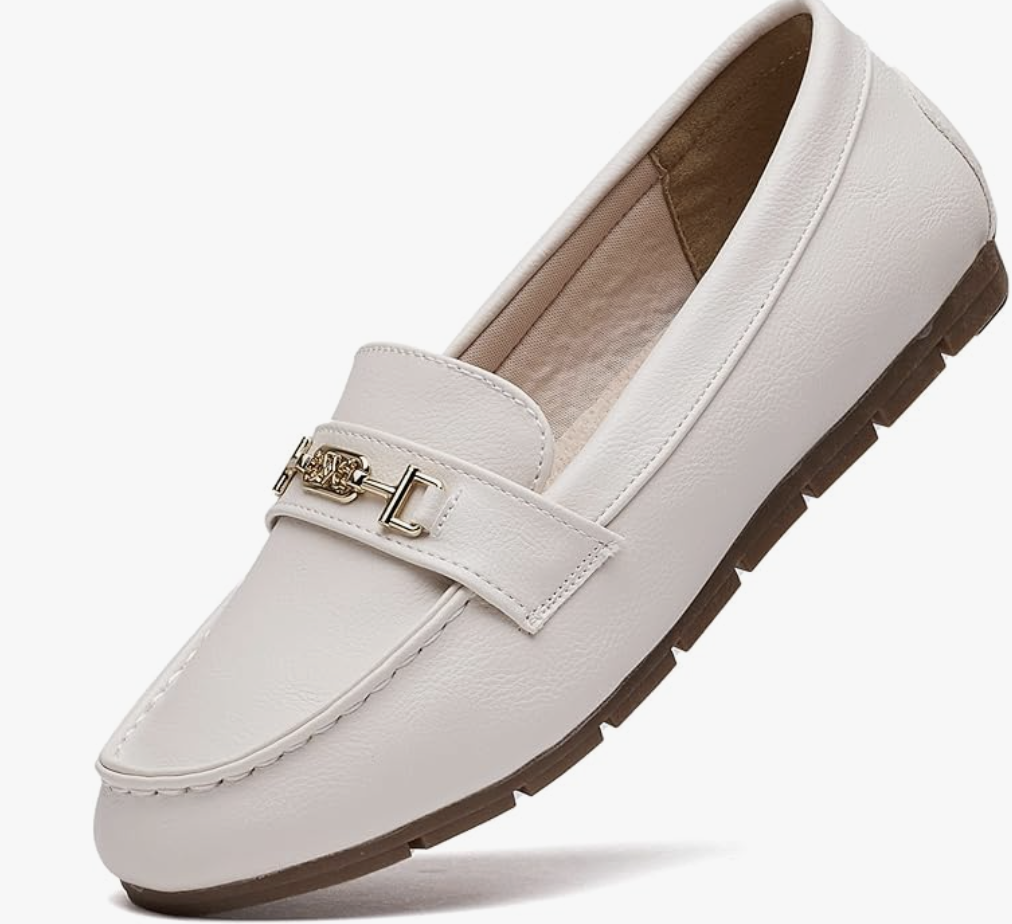 A product shot of a white slip-on loafer featuring a gold hardware bit across the top. This shoe is styled as a polished footwear choice to complete the high-texture monochrome outfit formula.