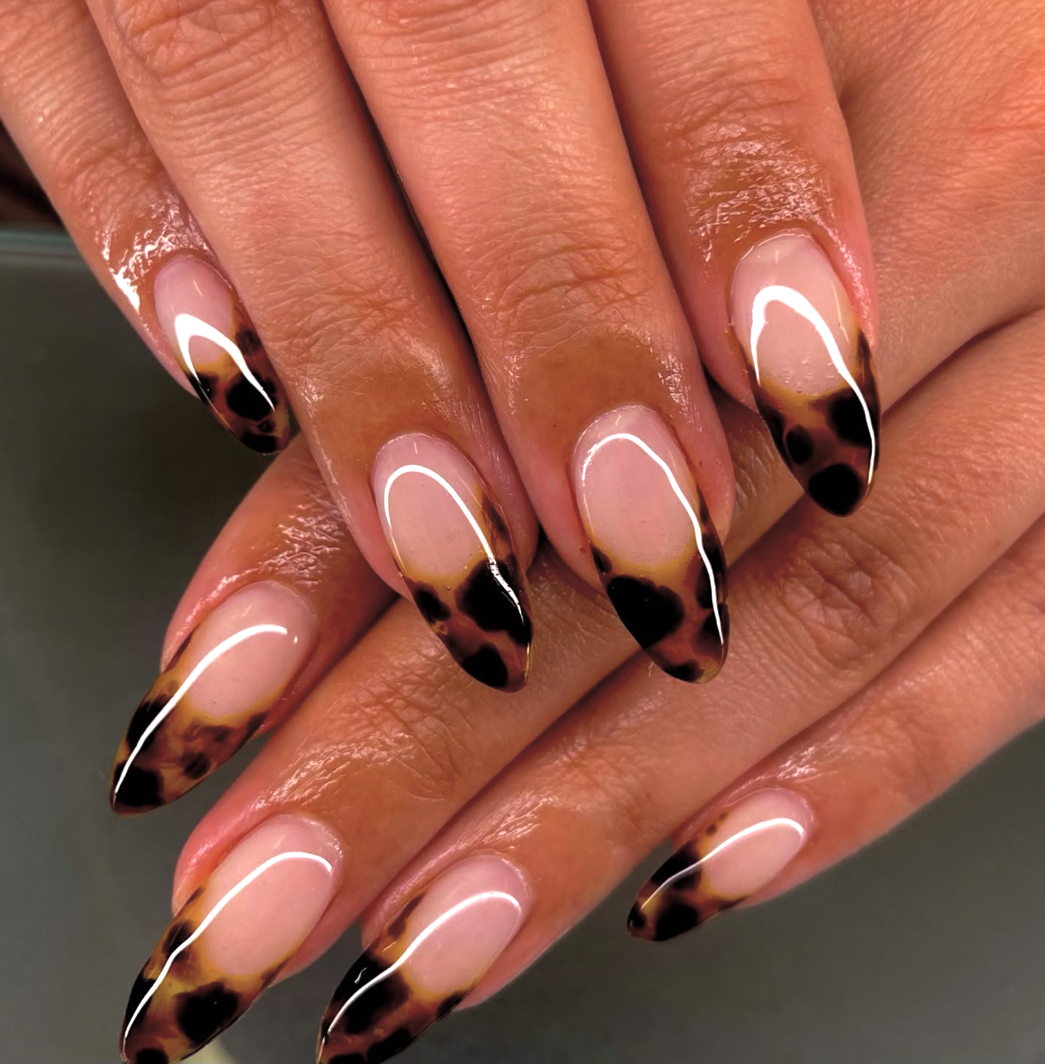 Brown manicure with amber and dark brown tortoiseshell accent nails.
