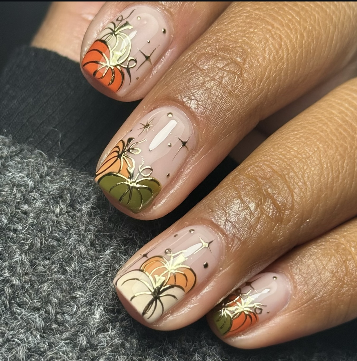 Soft sage-green pumpkin nail art over a creamy neutral base