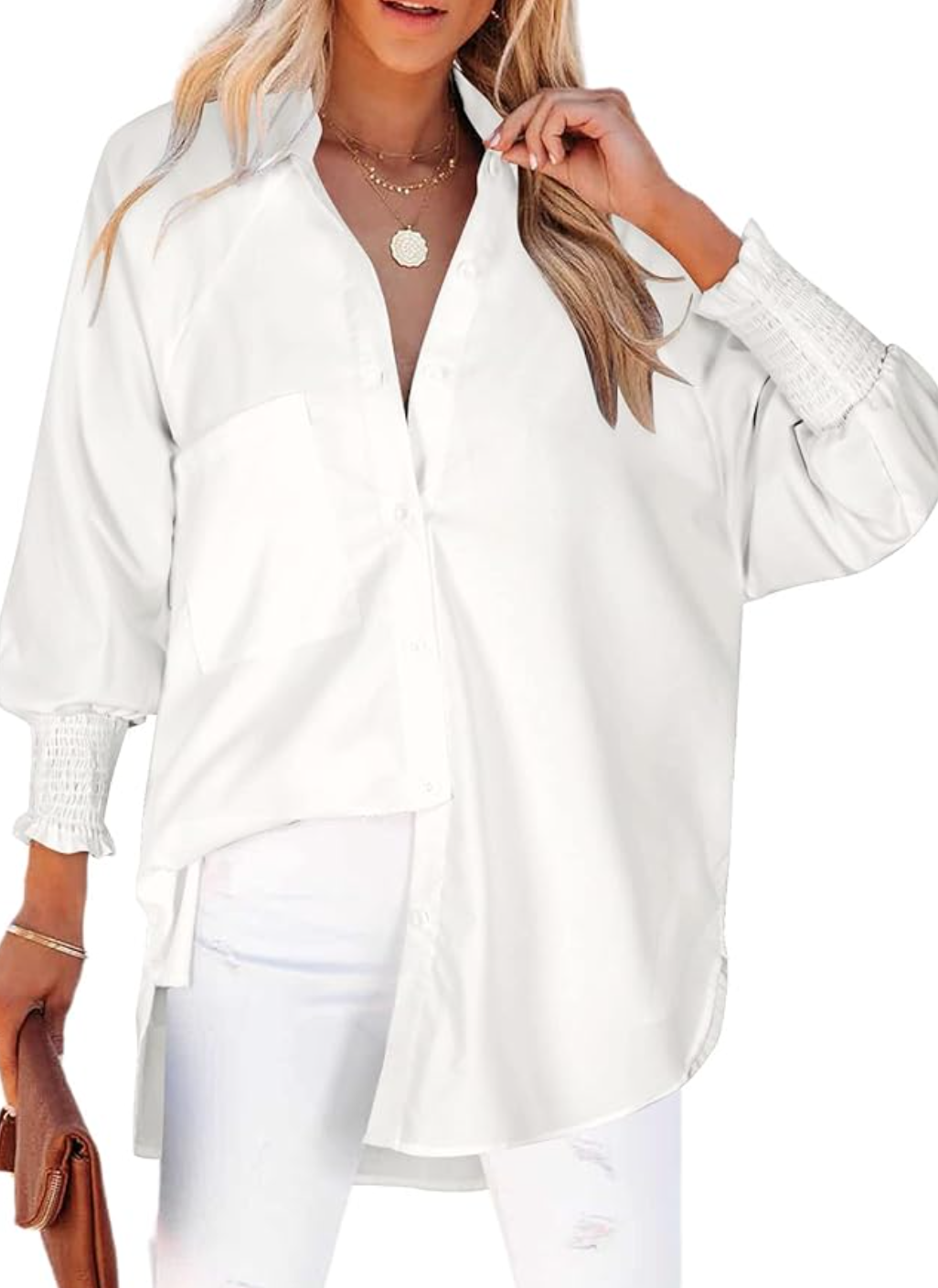 A woman wearing a crisp, white Oversized Button Down shirt with smocked cuffs and a high-low hem, styled with white trousers as part of a professional office capsule wardrobe.