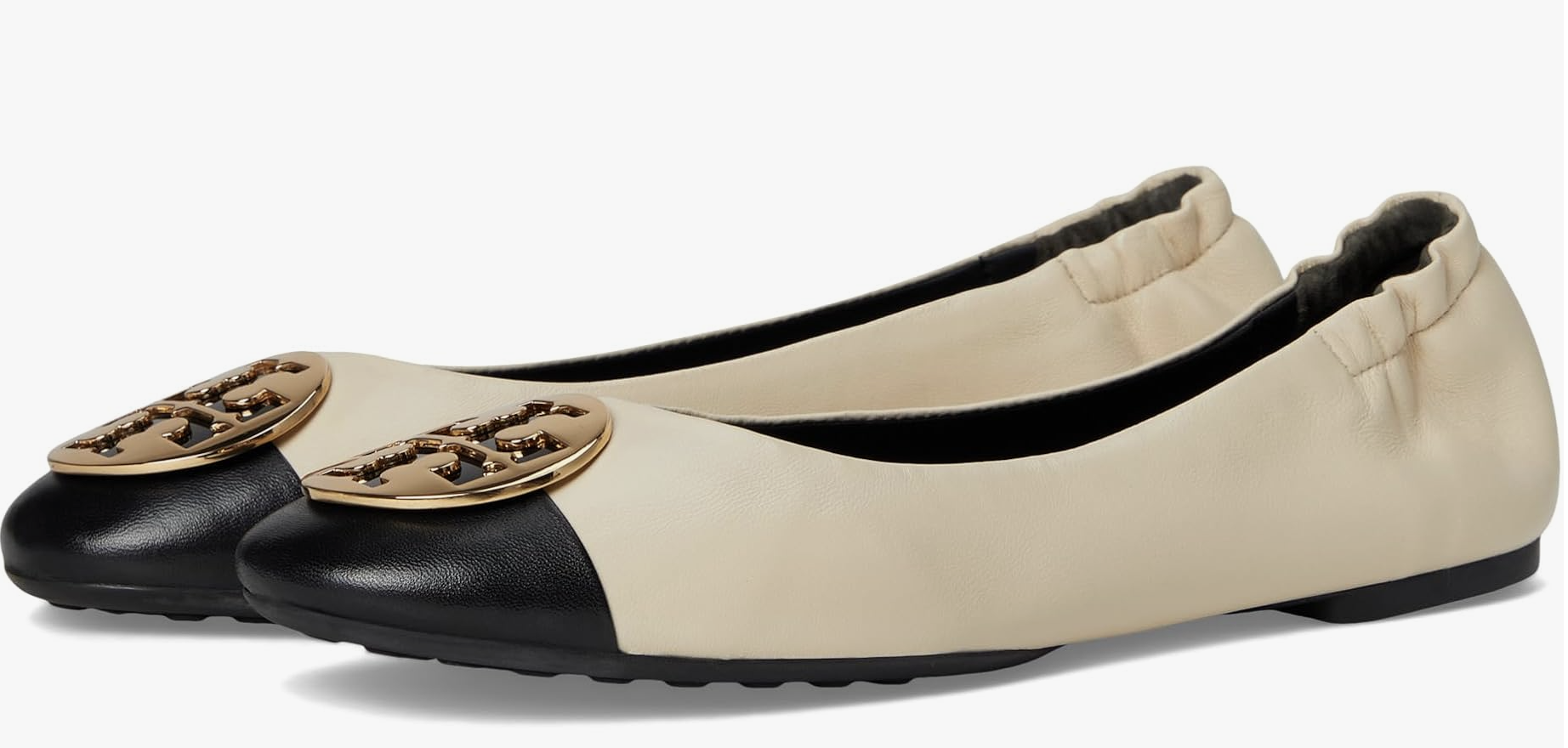 A pair of Tory Burch Claire Cap Toe Ballet flats in a cream and black color-block leather with a gold logo detail.
