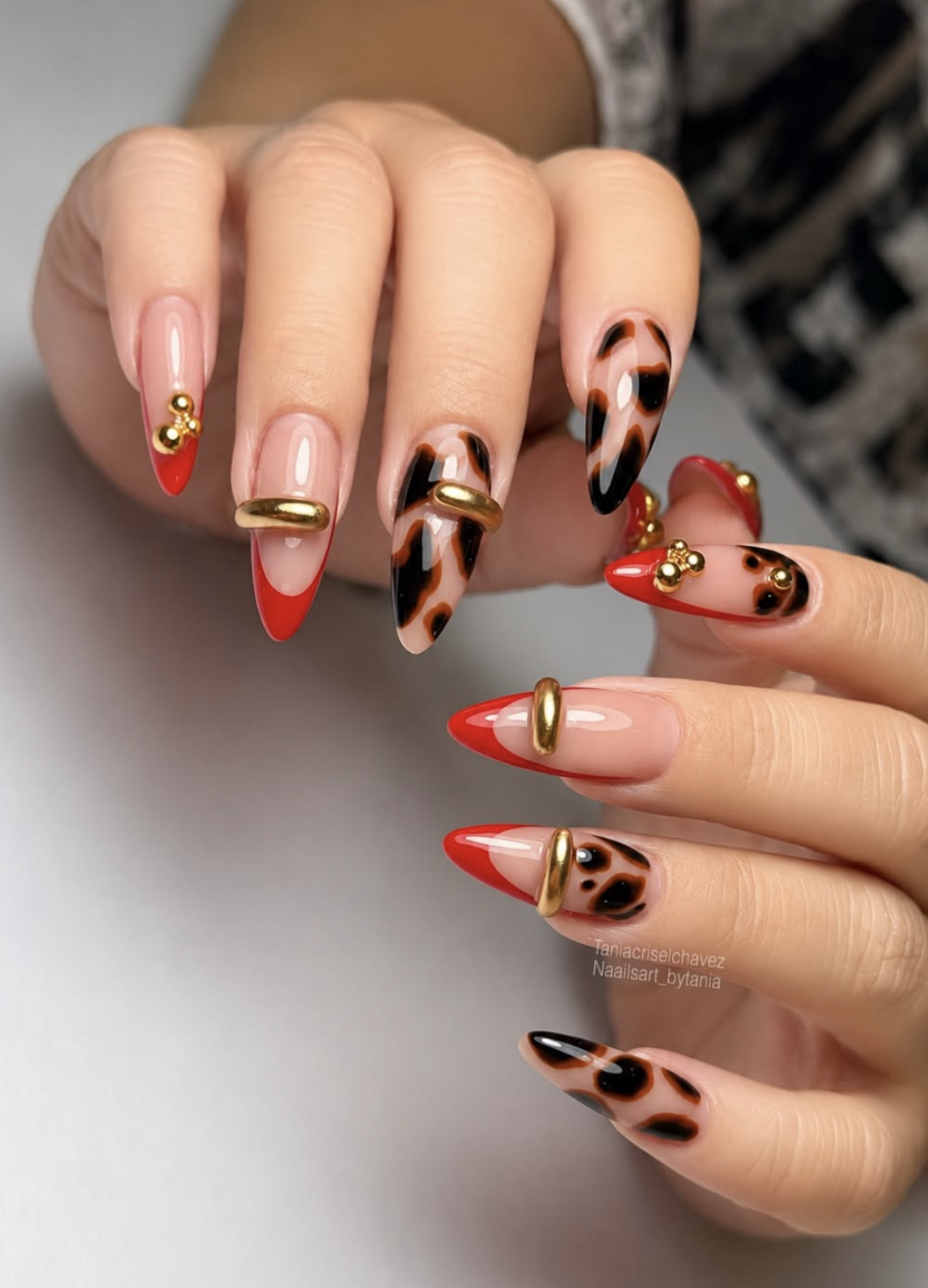 Glossy red nails with a thin gold cuff accent