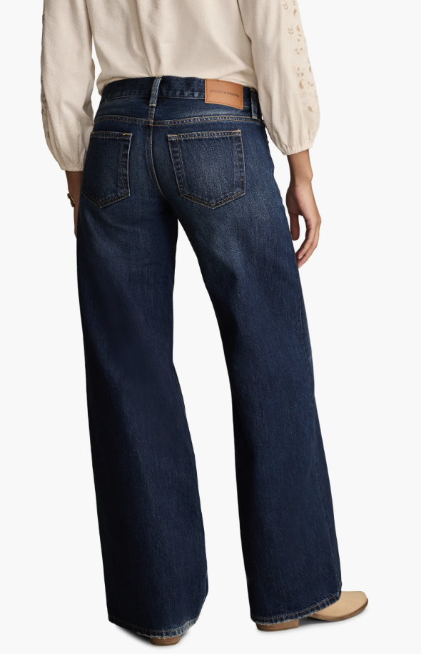 Woman wearing Lucky Brand ultra low-rise baggy wide-leg jeans in a dark ink wash with a heavyweight cotton finish.
