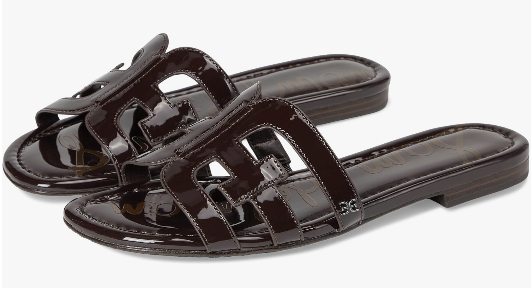 A pair of Sam Edelman Bay Slide sandals in dark chocolate brown patent leather with a cutout strap design on a white background.