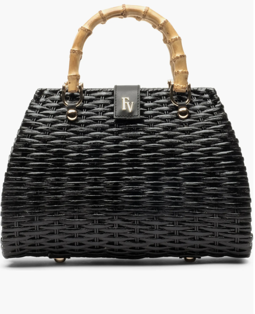 Black woven wicker top handle handbag with bamboo handles, a trending textured accessory for a spring 2026 wardrobe.
