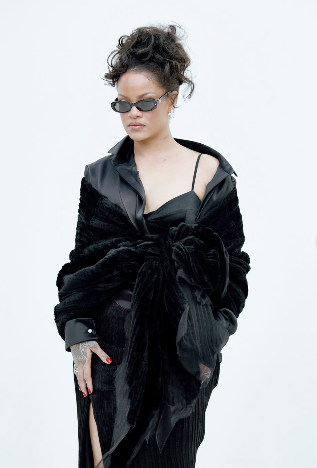 Rihanna attends Dior’s Spring 2027 Paris Fashion Week show in a black slit dress with diamond jewelry and a jeweled anklet.